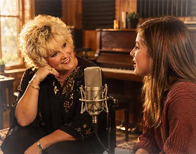 Vicki Lee coaching a student one-on-one at the microphone inside Studio 105 Recording